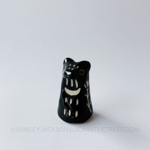 Small sgraffito bear totem done with black underglaze and finished with clear glaze.