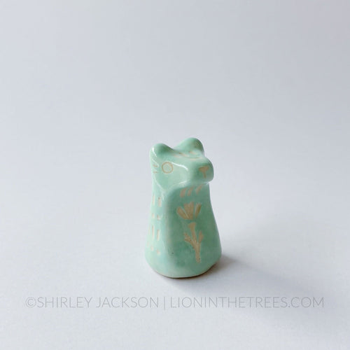 Small sgraffito bear totem done with pastel teal underglaze and finished with clear glaze.