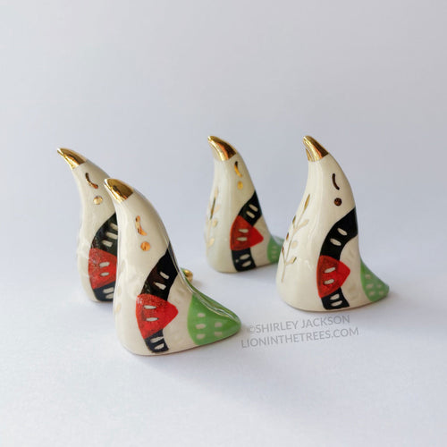 Dove totems done with black, red, and green underglazes that mimic the Palestinian flag; finished with clear glaze and gold overglaze details such as an olive tree branch motif.