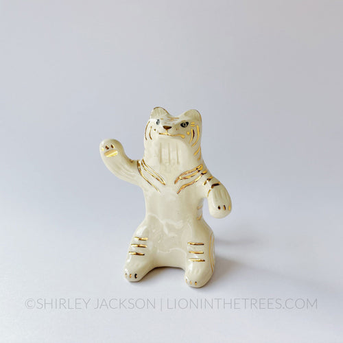 White wave tiger totem done with black underglaze, finished with clear glaze and gold overglaze details that create the stripes and California Poppy motif on the back.